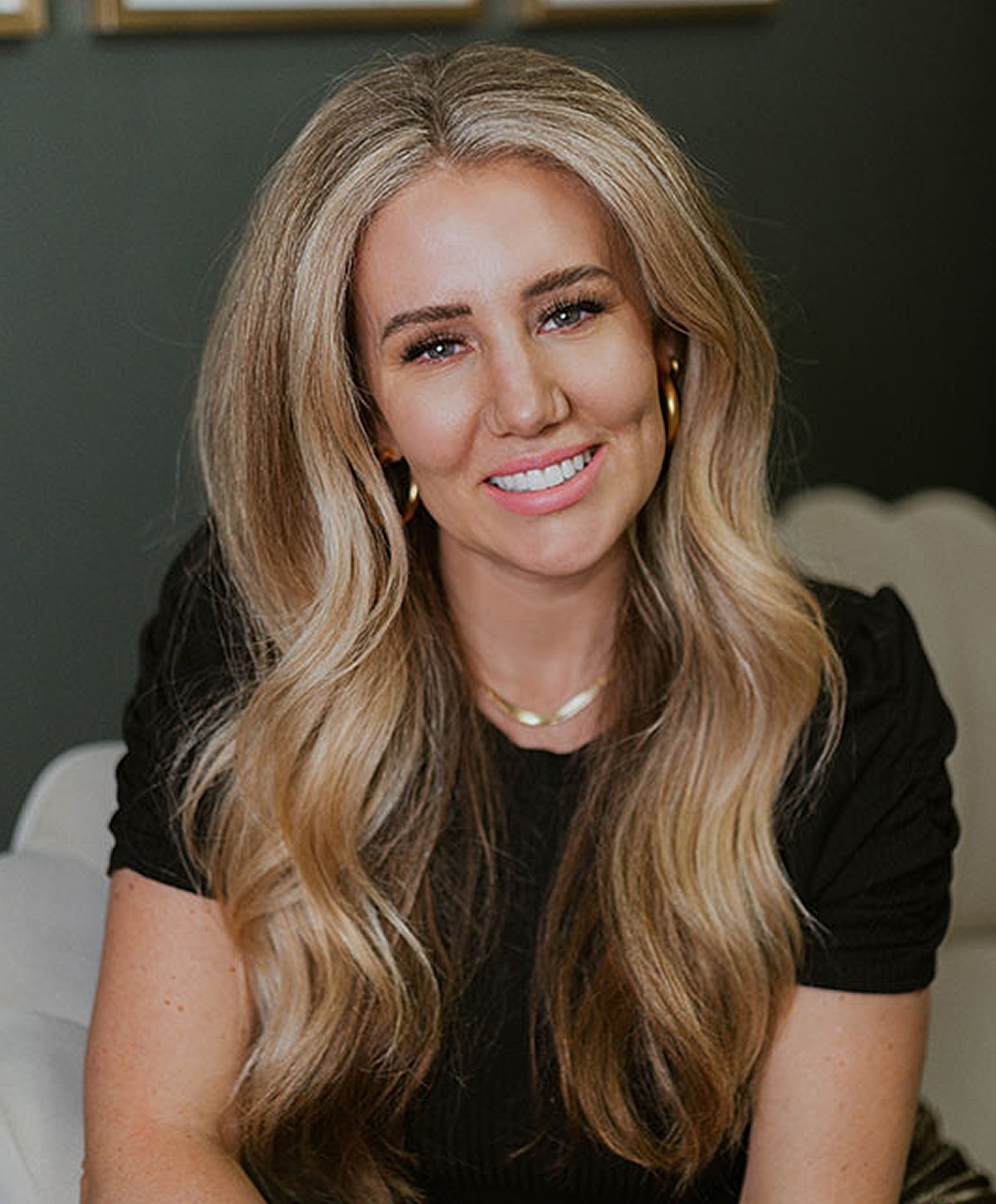 Smiling woman with long, wavy blonde hair.