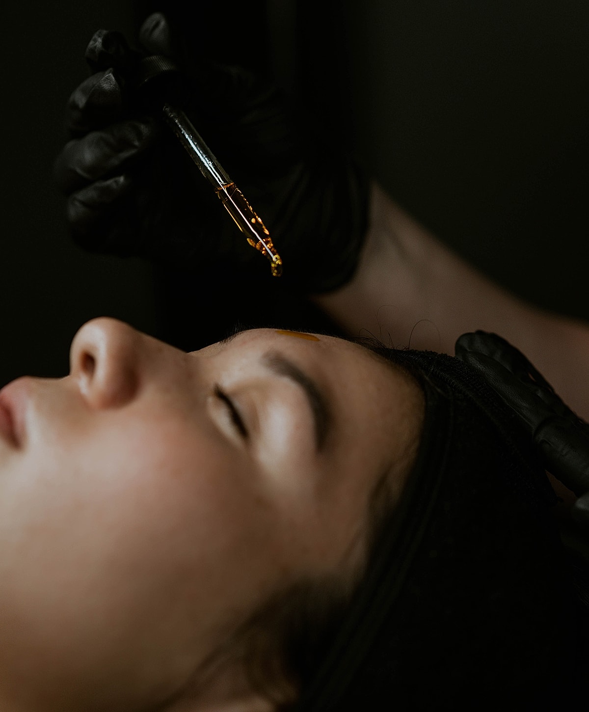 Applying facial treatment with a dropper.