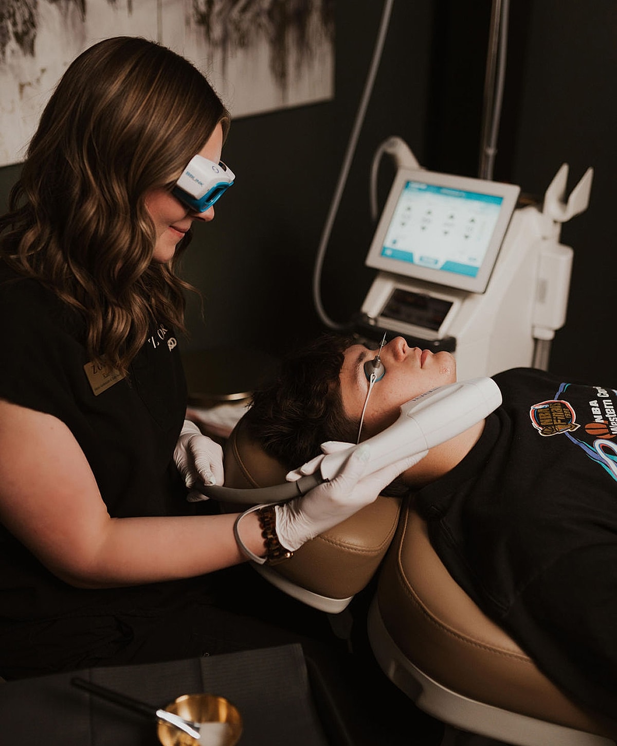 Woman performing treatment on client in clinic.