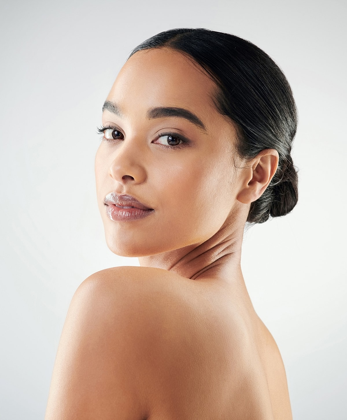 Woman with sleek hair and natural makeup.