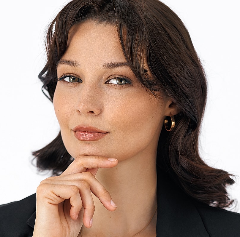 Thoughtful woman with hand on chin, elegant look.