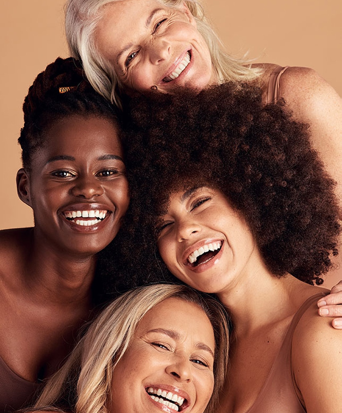 Four women sharing joyful smiles together.