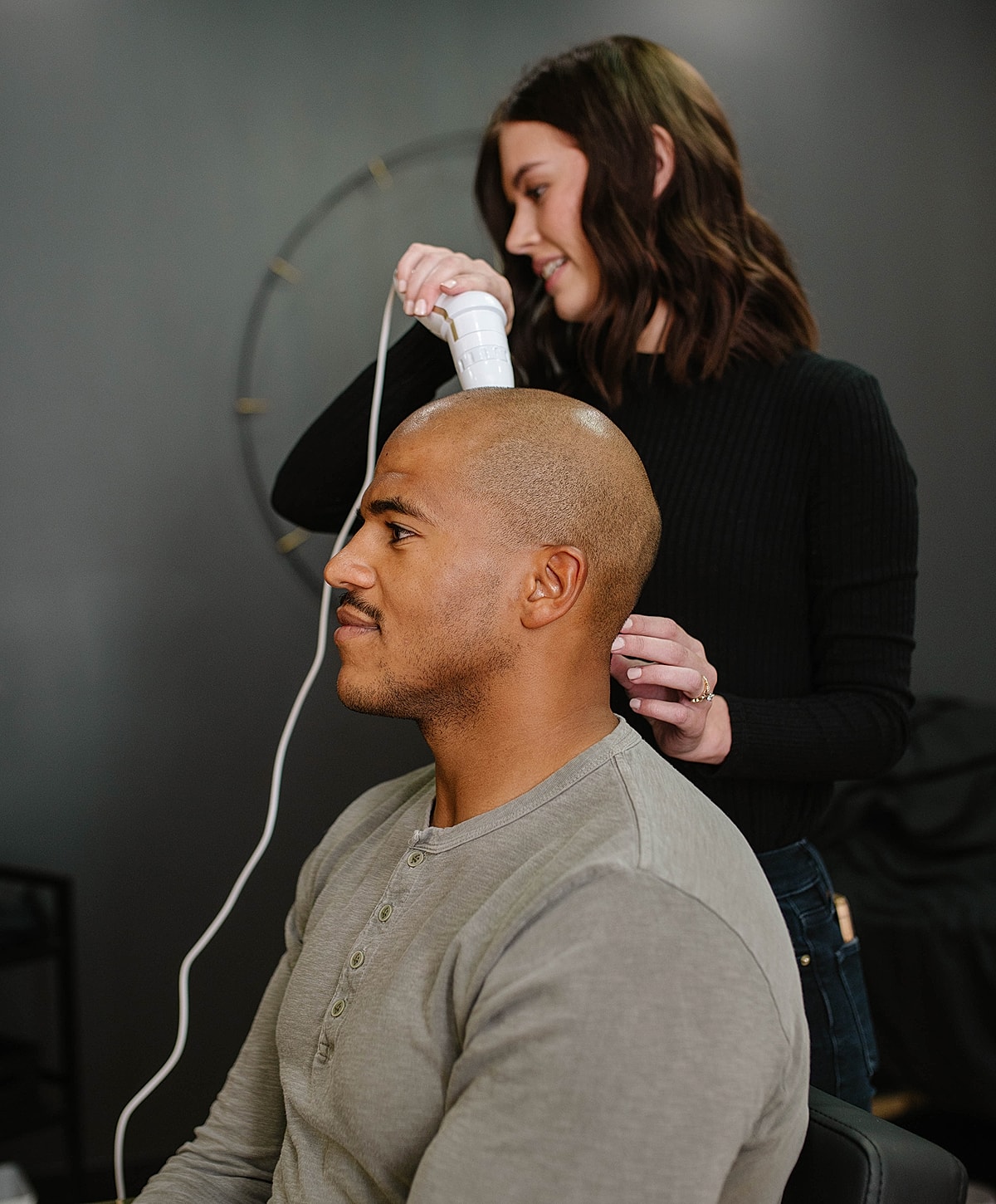 Client receiving scalp treatment at salon.