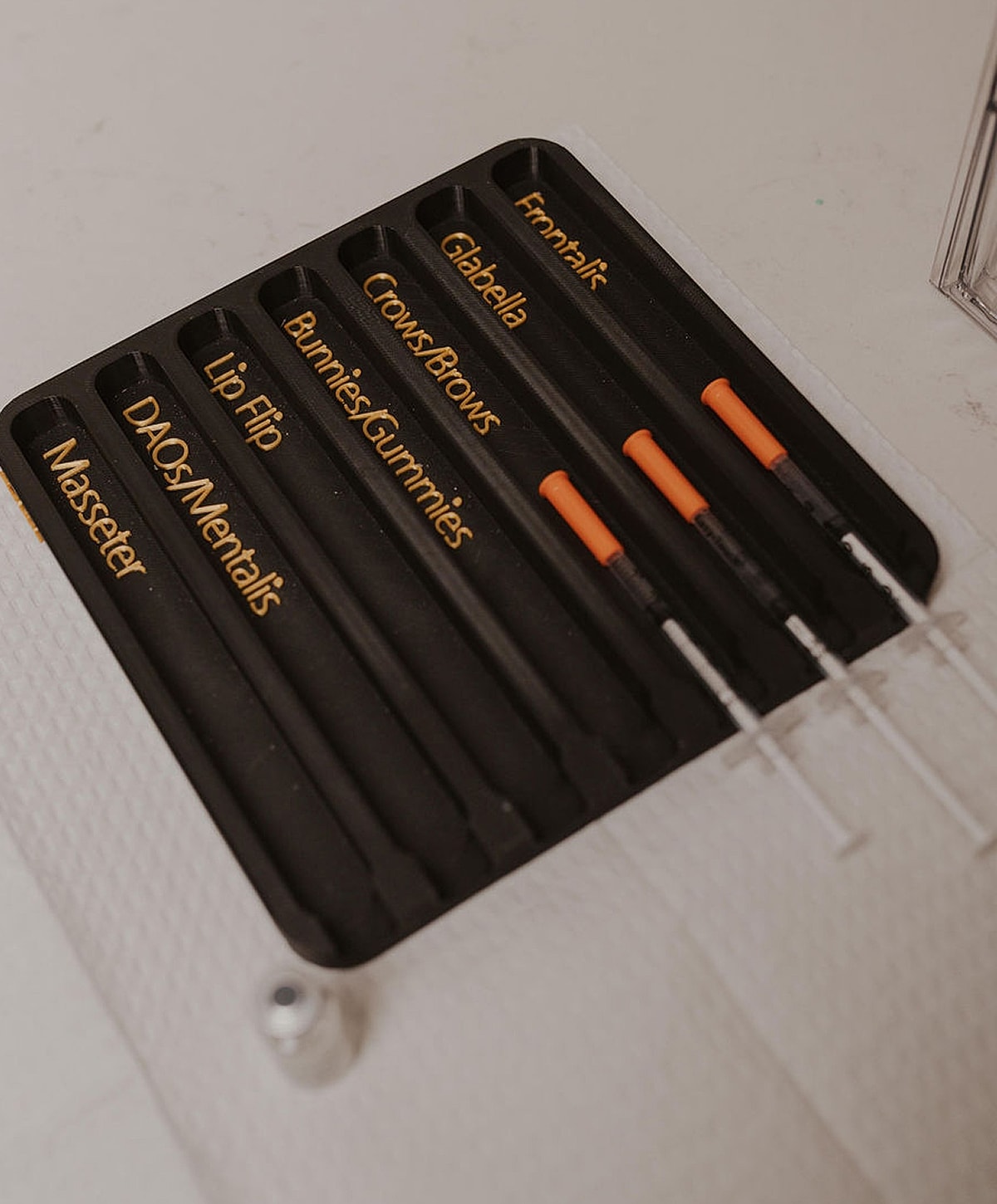 Cosmetic syringe tools arranged in a tray.