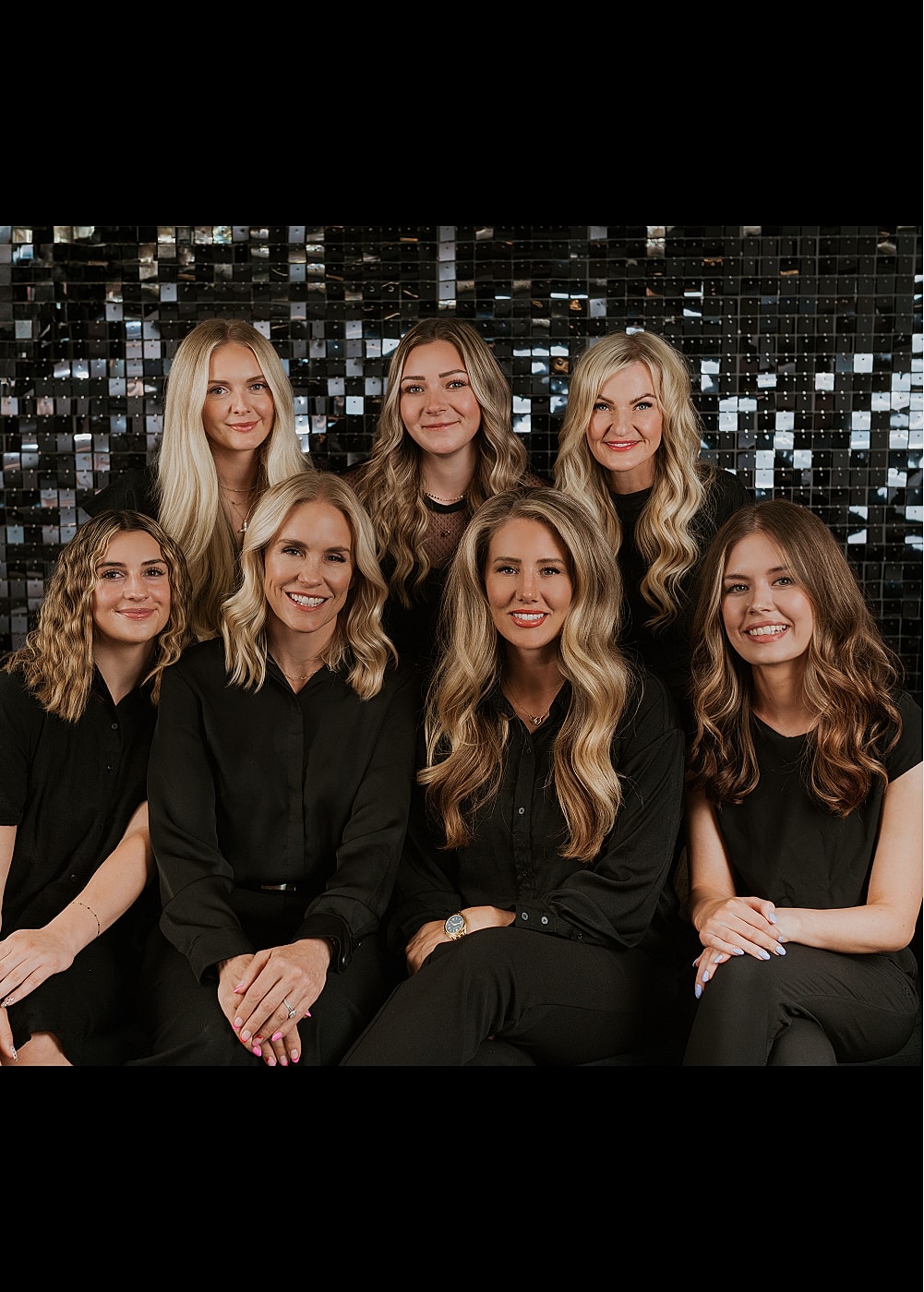Team of professionals smiling together in salon.