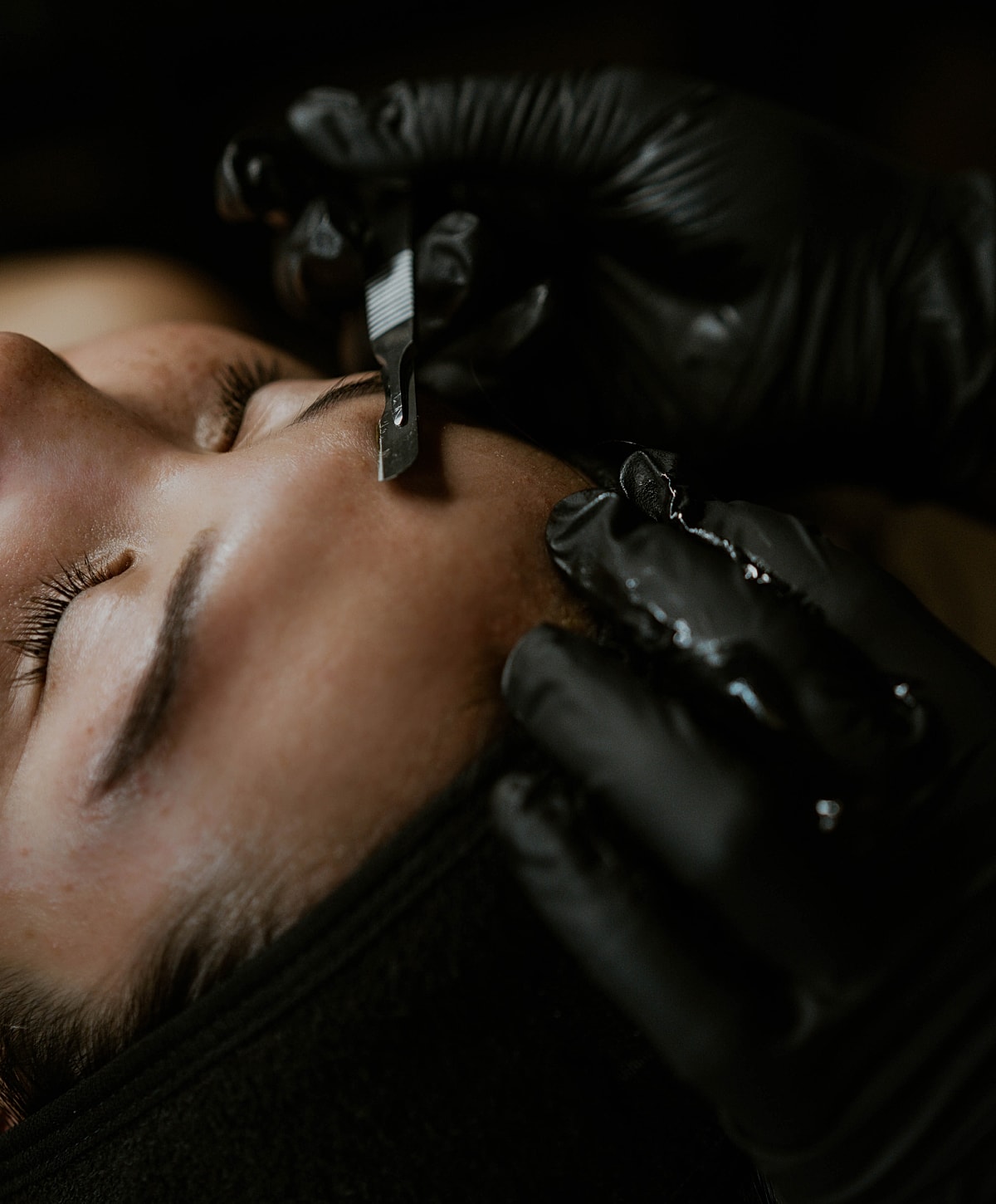 Applying dye to eyebrows during beauty treatment.