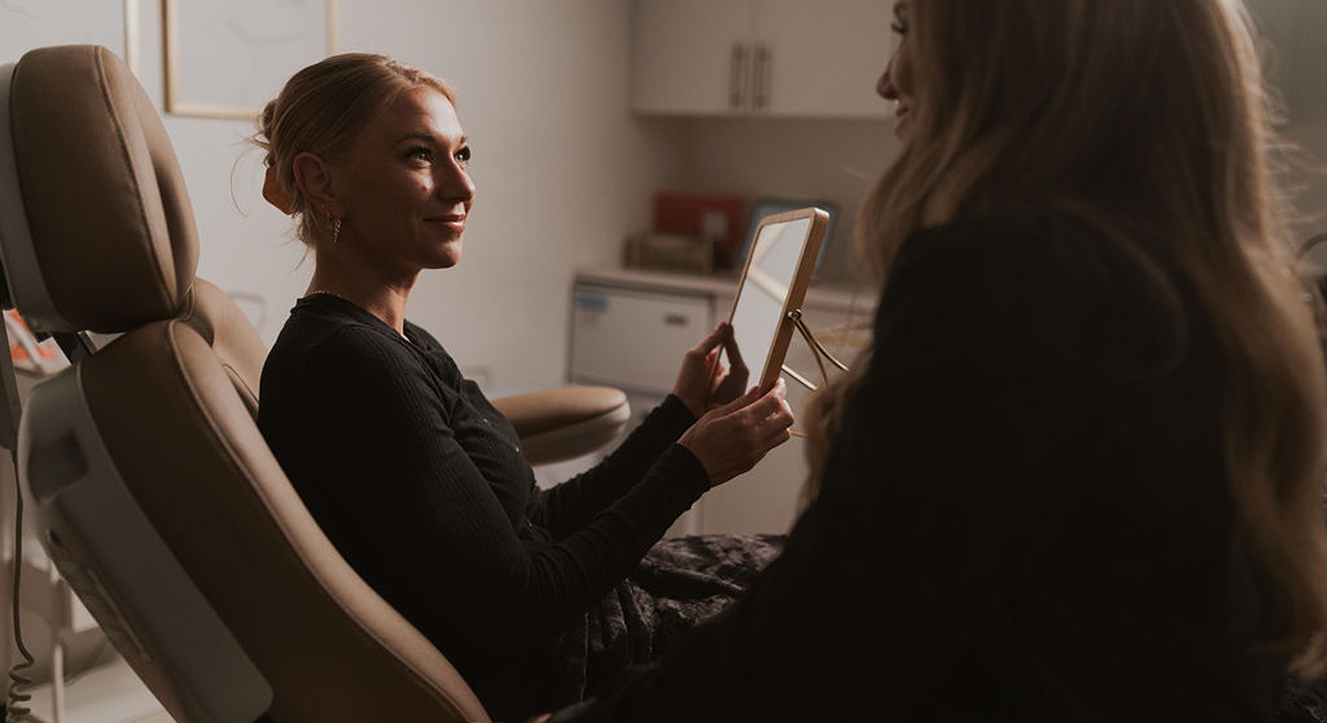 Woman observing her reflection in a mirror.